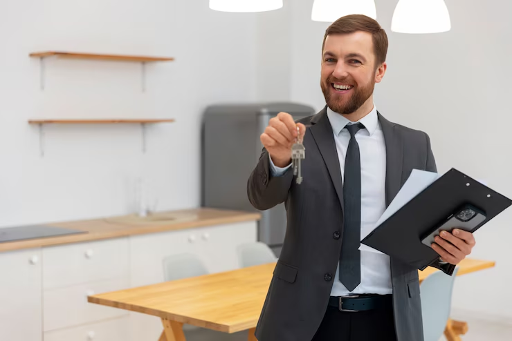 corretor de seguros segurando chave e sorrindo